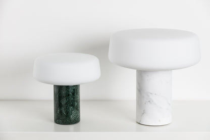 Terence Woodgate Solid Rechargeable table light in Serpentine marble and Table light in Bianco Carrera on a white shelf 