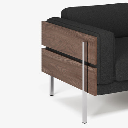 Black sofa with wooden side and silver legs on a white background